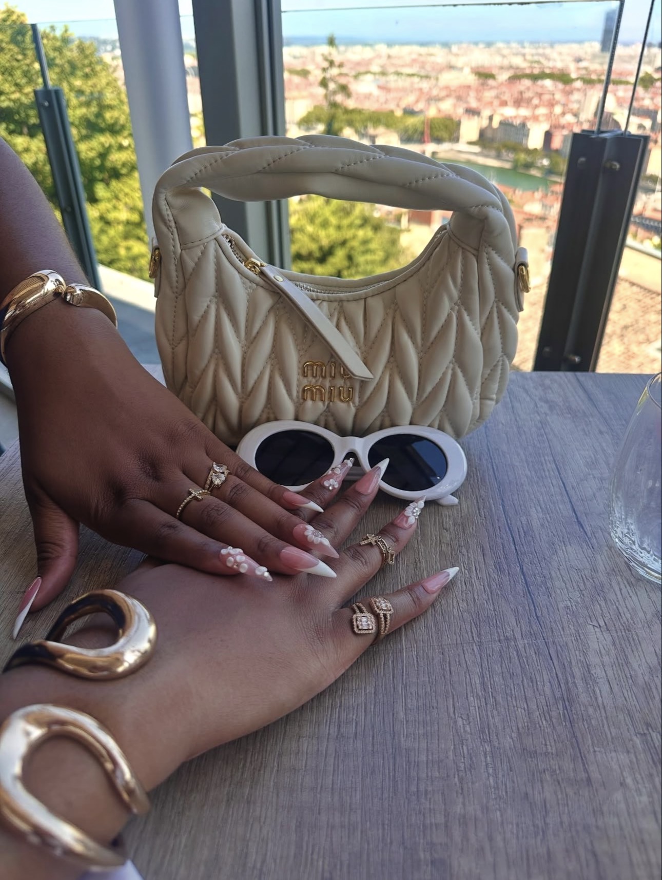 Gros plan du bracelet Fashion Nova porté avec une manucure rose