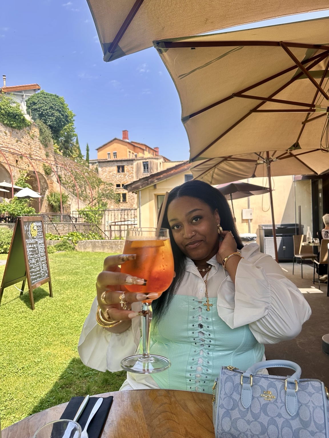 Mercedes tenant un verre sur une terrasse ensoleillée